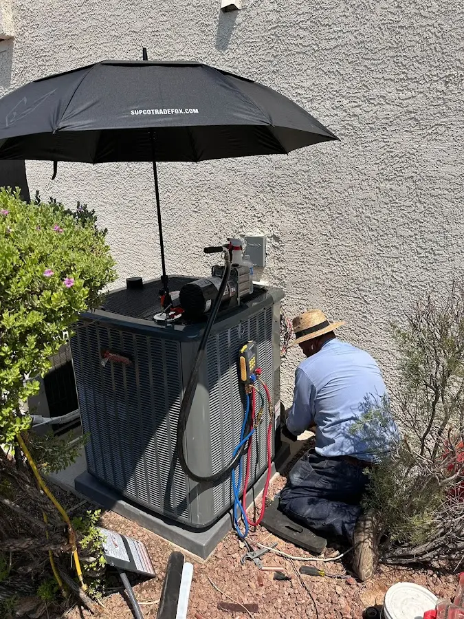 HVAC technician performing outdoor AC maintenance in East Fallowfield