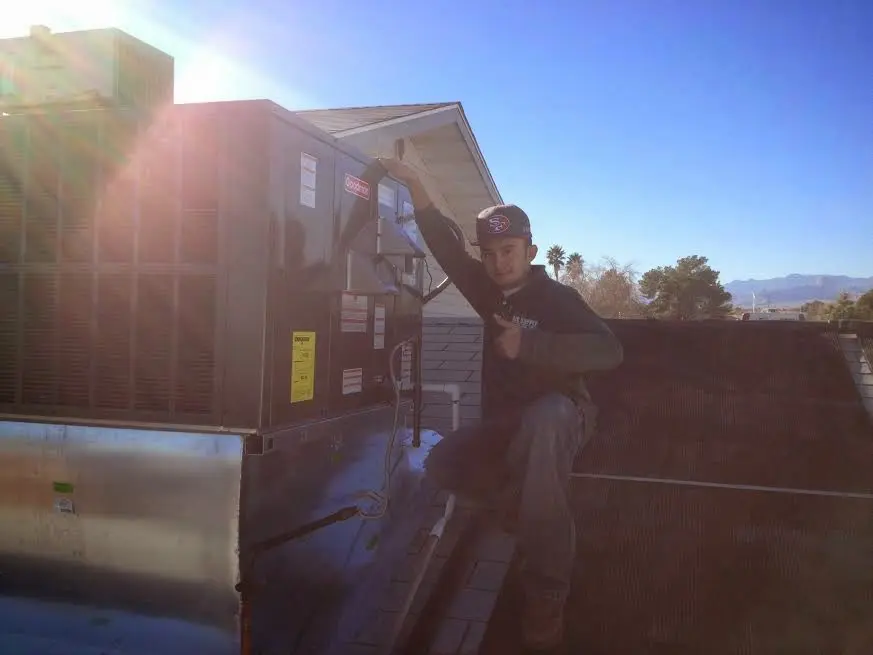 HVAC technician performing AC Tune-Up on a rooftop unit in East Fallowfield